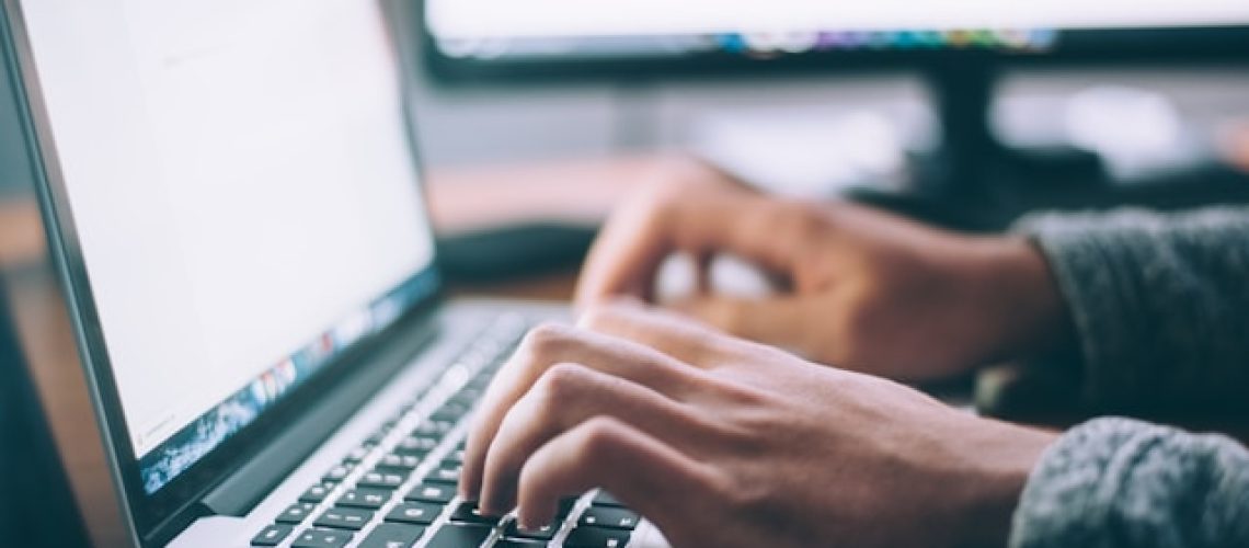 someone typing at a macbook keyboard